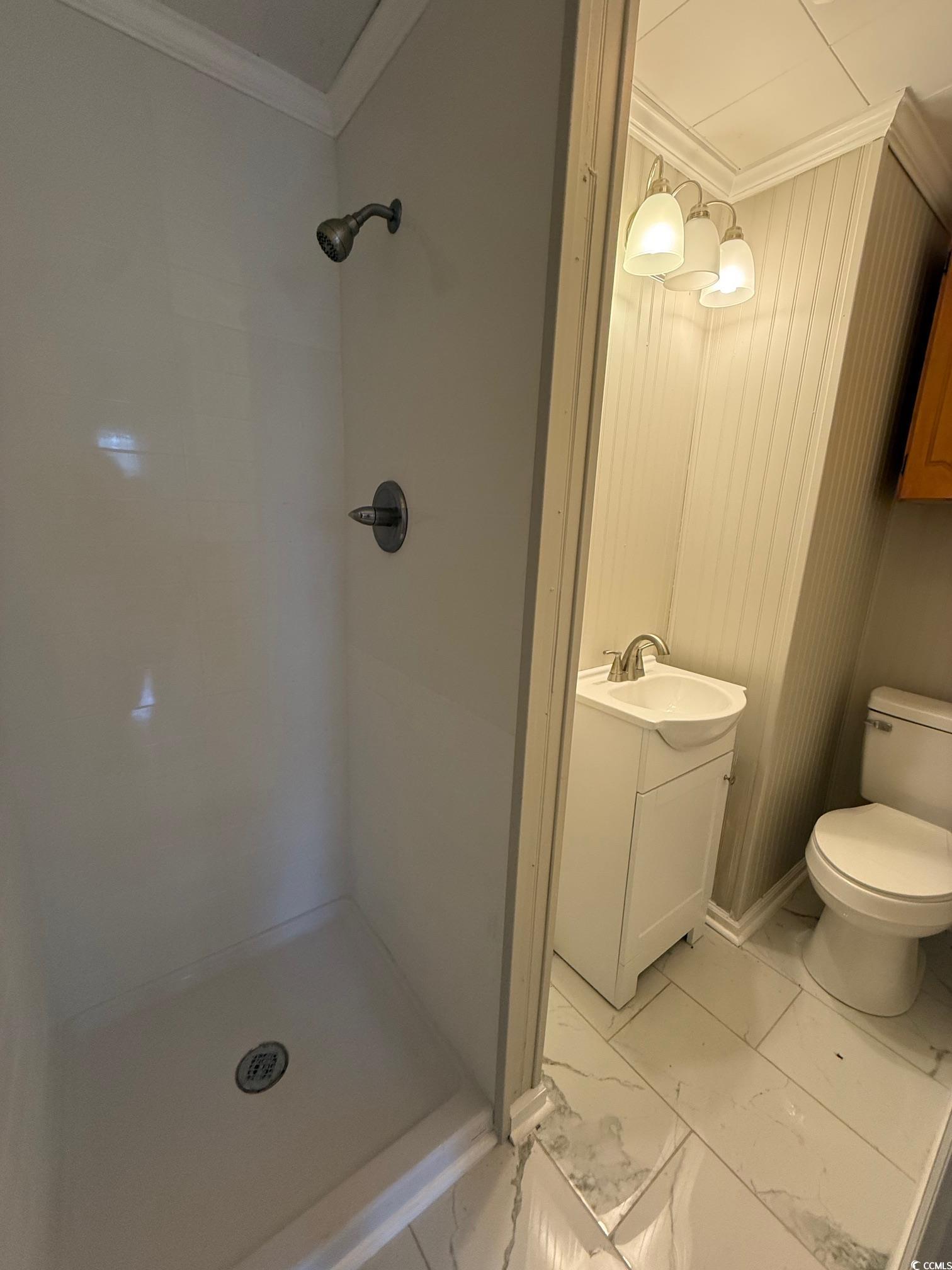 305 East Bamberg Street Latta, SC 29565 - Photo 9 of 13 Full bath featuring light marble finish floors, vanity, crown molding, and a shower stall