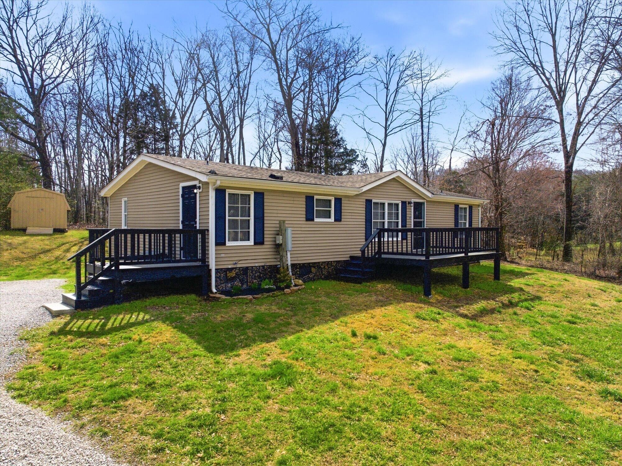 64 County Road 100 Decatur, TN 37322 - Photo 1 of 43 a view of a house with a big yard and large trees