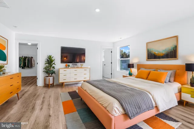 a spacious bedroom with a bed and a flat screen tv