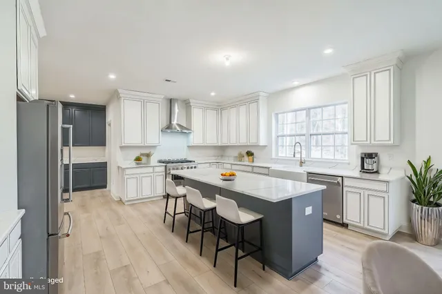 a kitchen with stainless steel appliances granite countertop a table chairs sink refrigerator and cabinets