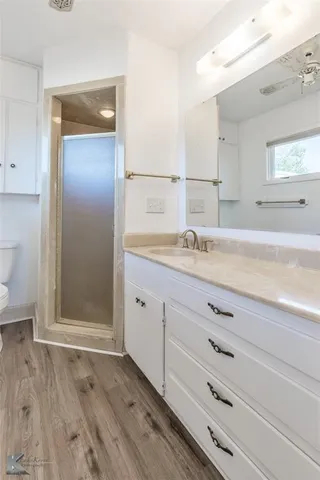 a bathroom with a granite countertop sink toilet and shower