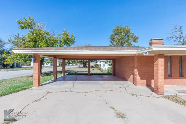 front view of a brick house with a yard