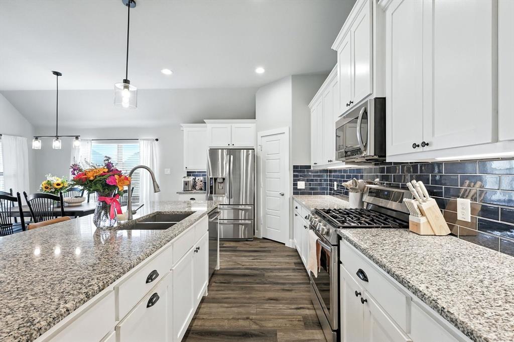 705 Chaparral Road Sanger, TX 76266 - Photo 13 of 38 a kitchen with stainless steel appliances granite countertop a sink stove and refrigerator