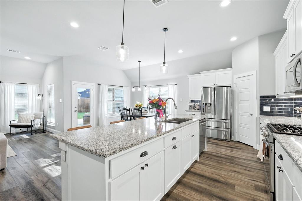 705 Chaparral Road Sanger, TX 76266 - Photo 14 of 38 a kitchen with stainless steel appliances granite countertop a sink a refrigerator and a wooden cabinets