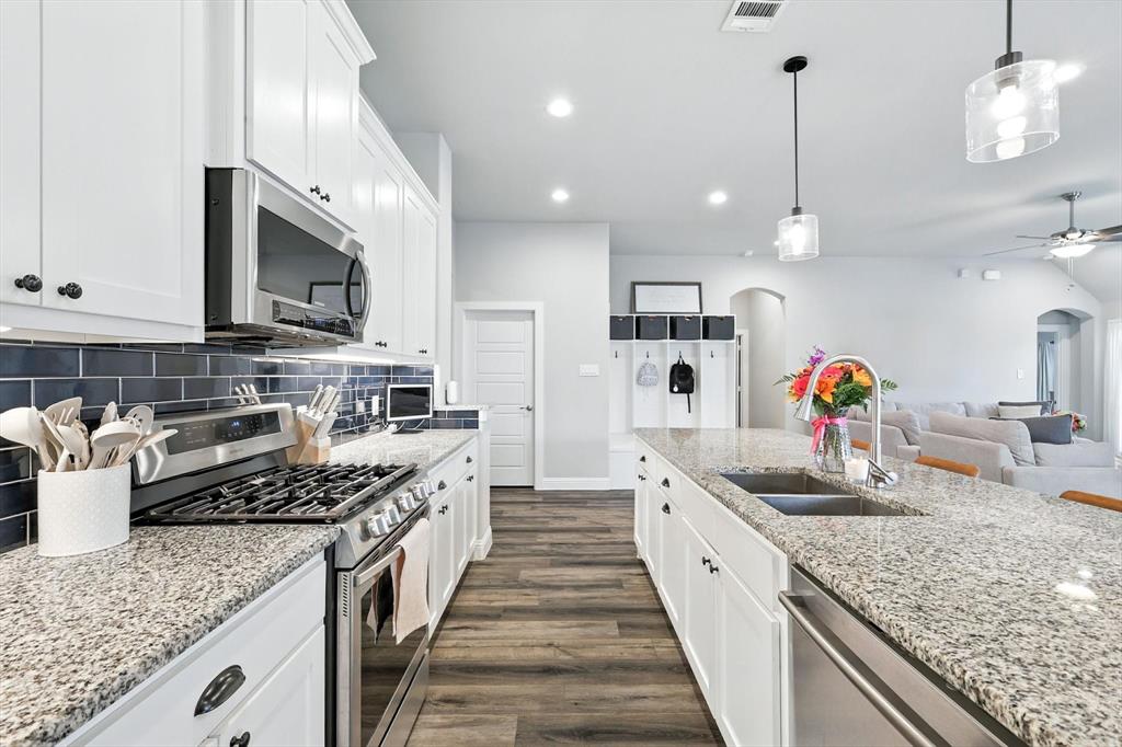 705 Chaparral Road Sanger, TX 76266 - Photo 15 of 38 a large kitchen with stainless steel appliances granite countertop a lot of counter space and wooden floor