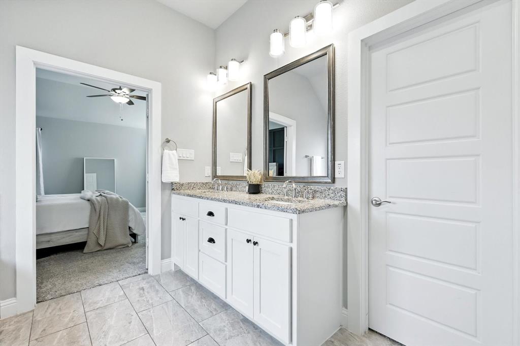 705 Chaparral Road Sanger, TX 76266 - Photo 21 of 38 a spacious bathroom with a granite countertop sink and a mirror
