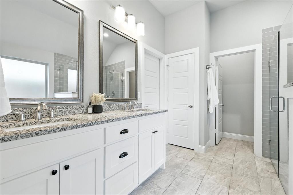 705 Chaparral Road Sanger, TX 76266 - Photo 23 of 38 a bathroom with a granite countertop sink two mirror and a shower