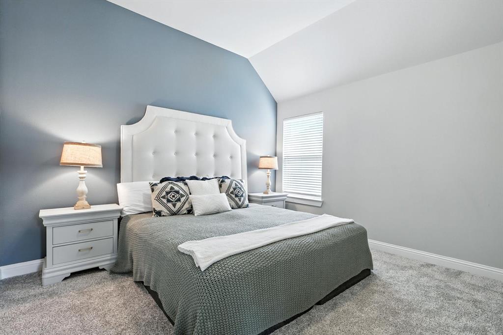 705 Chaparral Road Sanger, TX 76266 - Photo 25 of 38 a bedroom with a large bed and a lamp on table