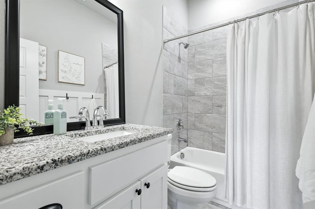 705 Chaparral Road Sanger, TX 76266 - Photo 27 of 38 a bathroom with a granite countertop sink a toilet and shower