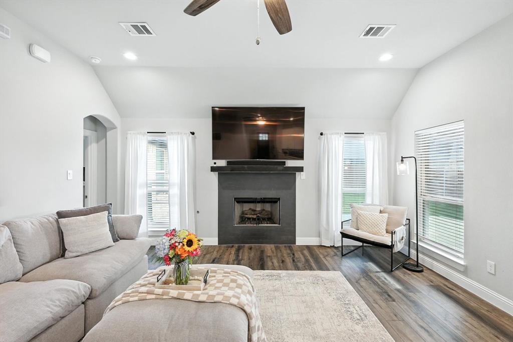 705 Chaparral Road Sanger, TX 76266 - Photo 7 of 38 a living room with furniture a fireplace and a flat screen tv