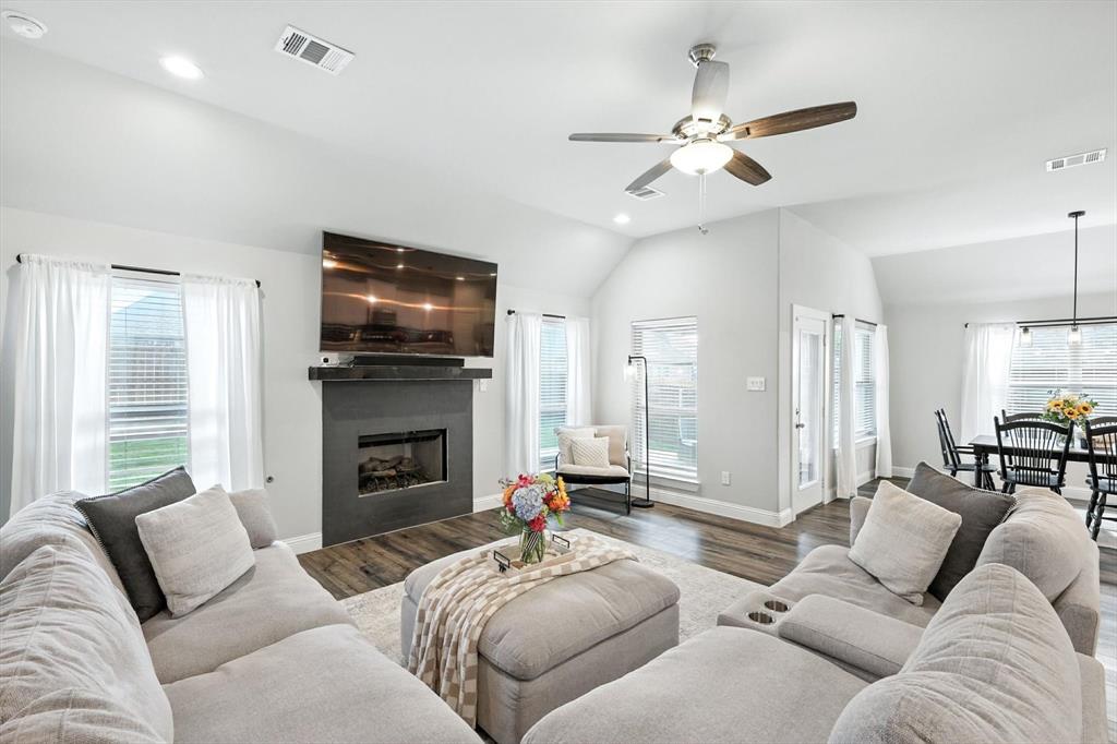 705 Chaparral Road Sanger, TX 76266 - Photo 8 of 38 a living room with furniture a fireplace and a flat screen tv