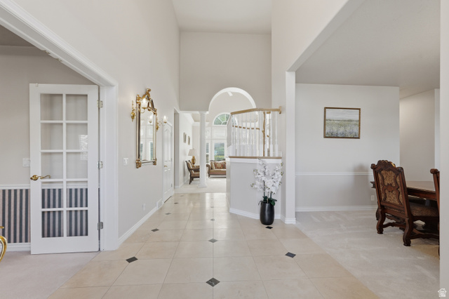 11943 Autumn Ridge Drive East Sandy, UT 84092 - Photo 6 of 59 Hall featuring a high ceiling, light colored carpet, light tile patterned floors, and arched walkways