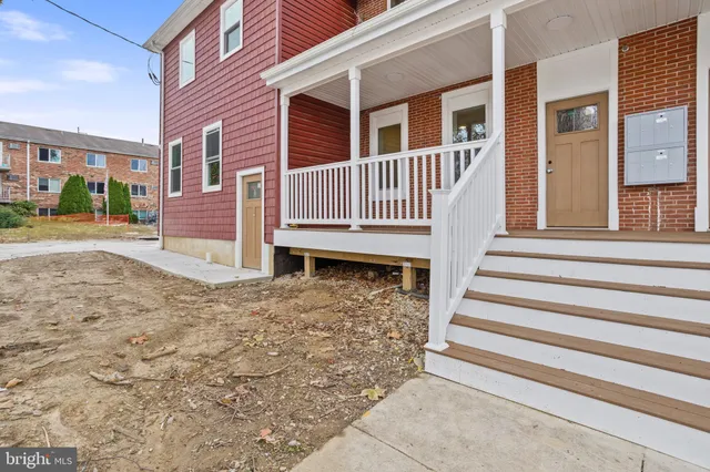 a view of a house with backyard and wooden fence