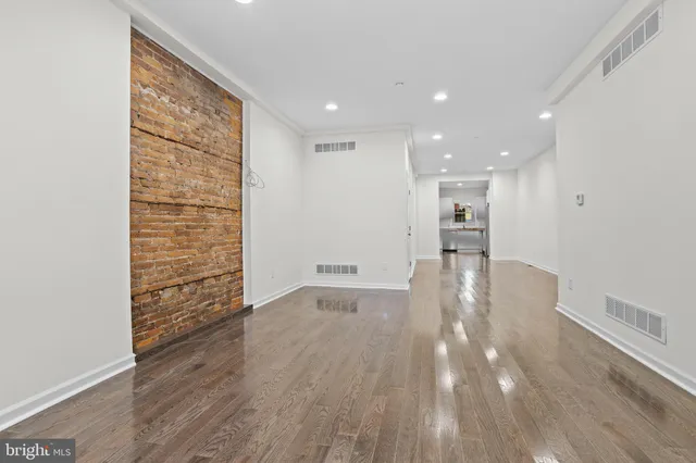 a view of empty room with wooden floor