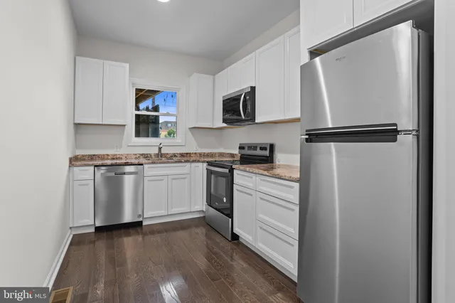 a kitchen with white cabinets and white appliances