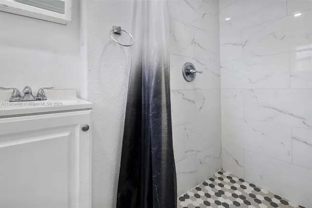 a bathroom with a sink a toilet a shower and a mirror