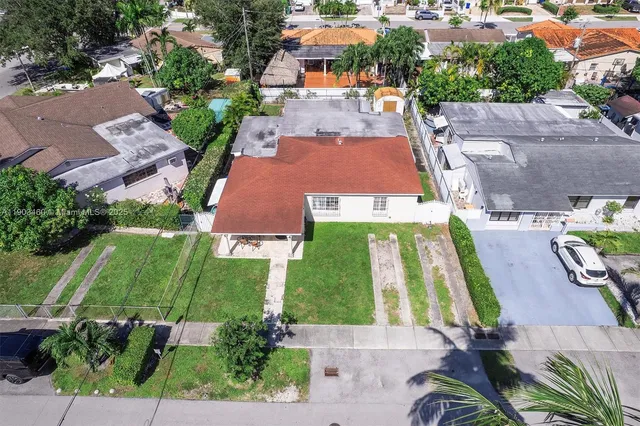 an aerial view of a house with garden space and street view