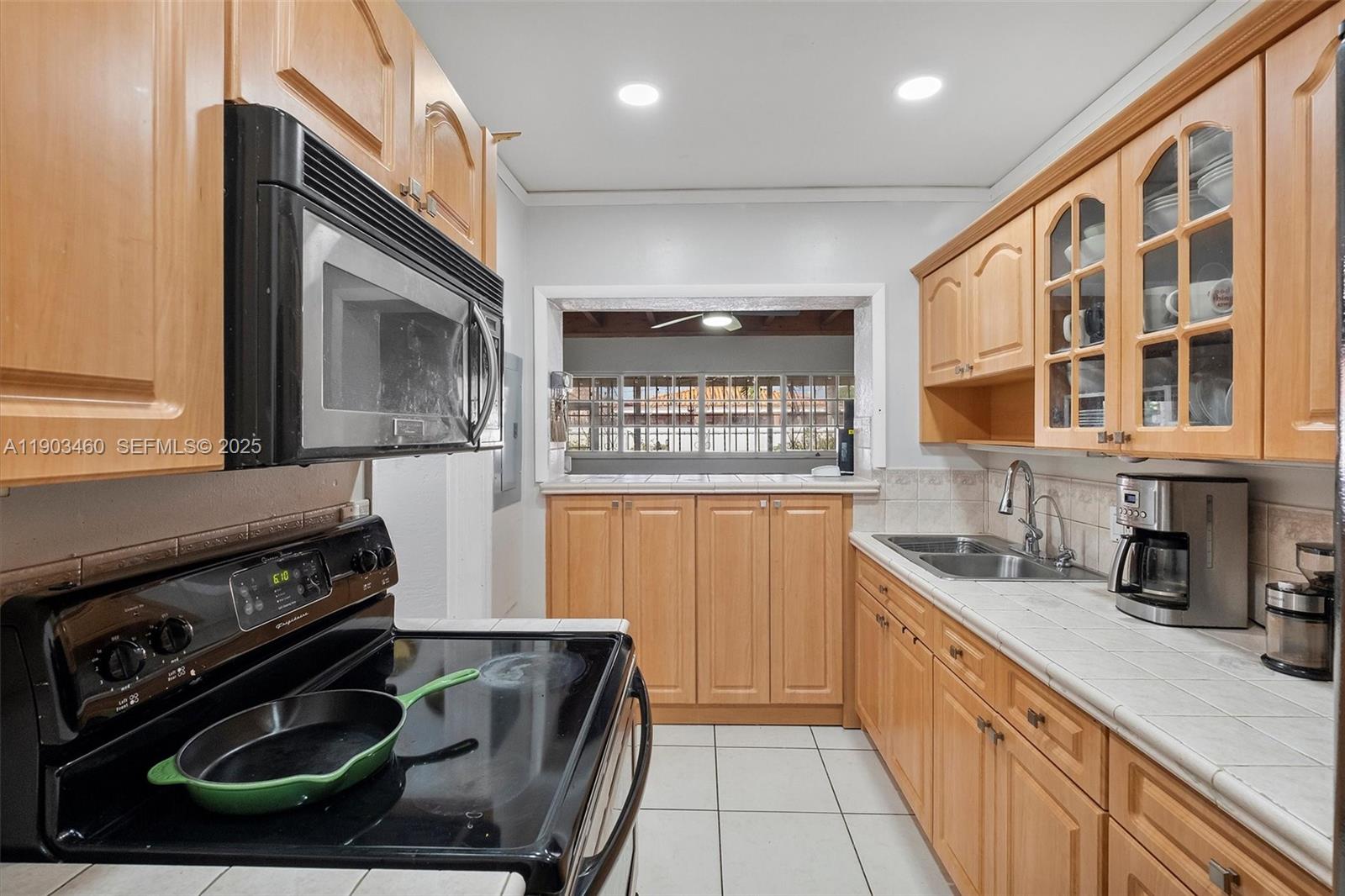 7231 Southwest 6th Street Miami, FL 33144 - Photo 7 of 34 a kitchen with stainless steel appliances granite countertop a stove a sink and a microwave