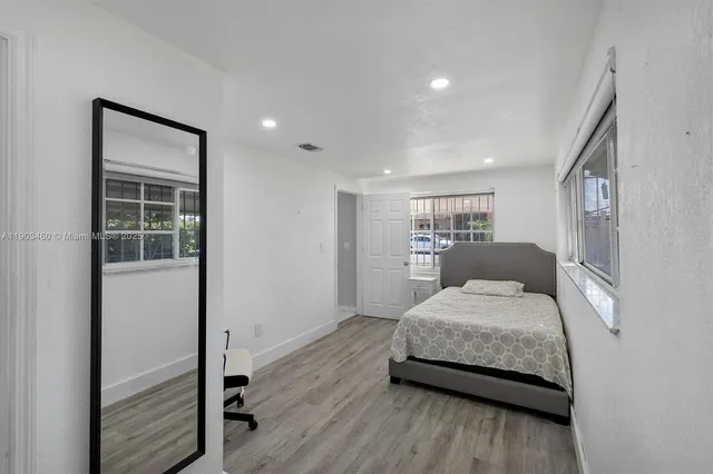 a bedroom with a bed and a view of kitchen