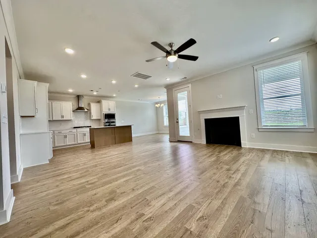 a view of kitchen with kitchen island wooden floor and stainless steel appliances