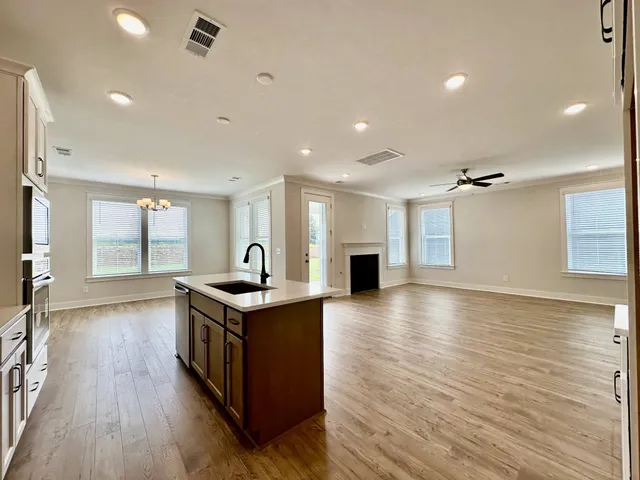 a kitchen with stainless steel appliances granite countertop a stove and a wooden floors