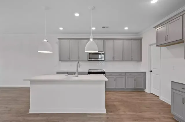 a kitchen with a sink stainless steel appliances and white cabinets