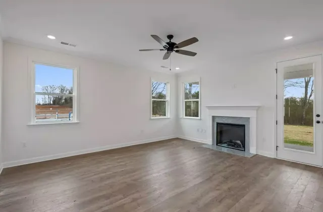 a view of empty room with wooden floor and fireplace
