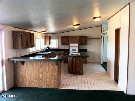 101 Byron Road Prosser, WA 99350 - Photo 2 of 14 a kitchen with kitchen island granite countertop a sink cabinets and stainless steel appliances