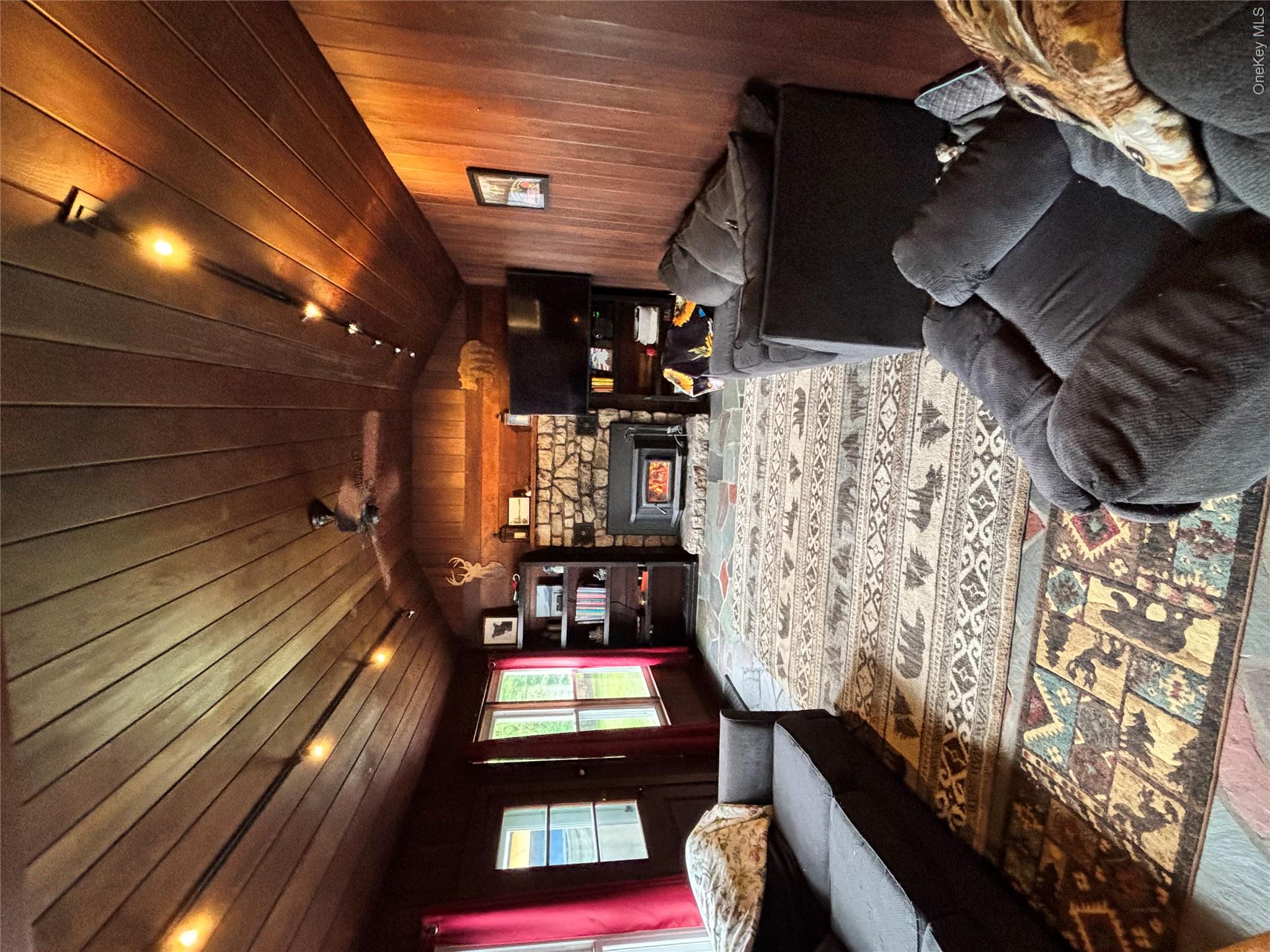 894 Upper Mountain Road Pine Bush, NY 12566 - Photo 8 of 35 Living room with wood walls, vaulted ceiling, wood ceiling, a fireplace, and wood finished floors