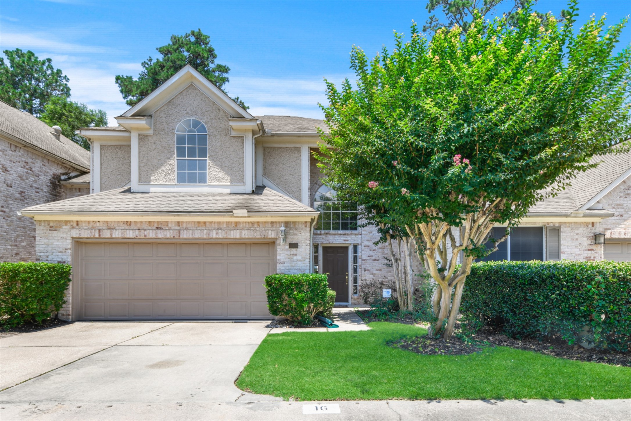 14420 Walters Road, Unit 16 Houston, TX 77014 - Photo 1 of 27 Charming two-story home with a brick exterior and arched window above the garage. Features a well-maintained front yard with lush greenery and a mature tree. Ideal for buyers seeking a cozy and inviting curb appeal.