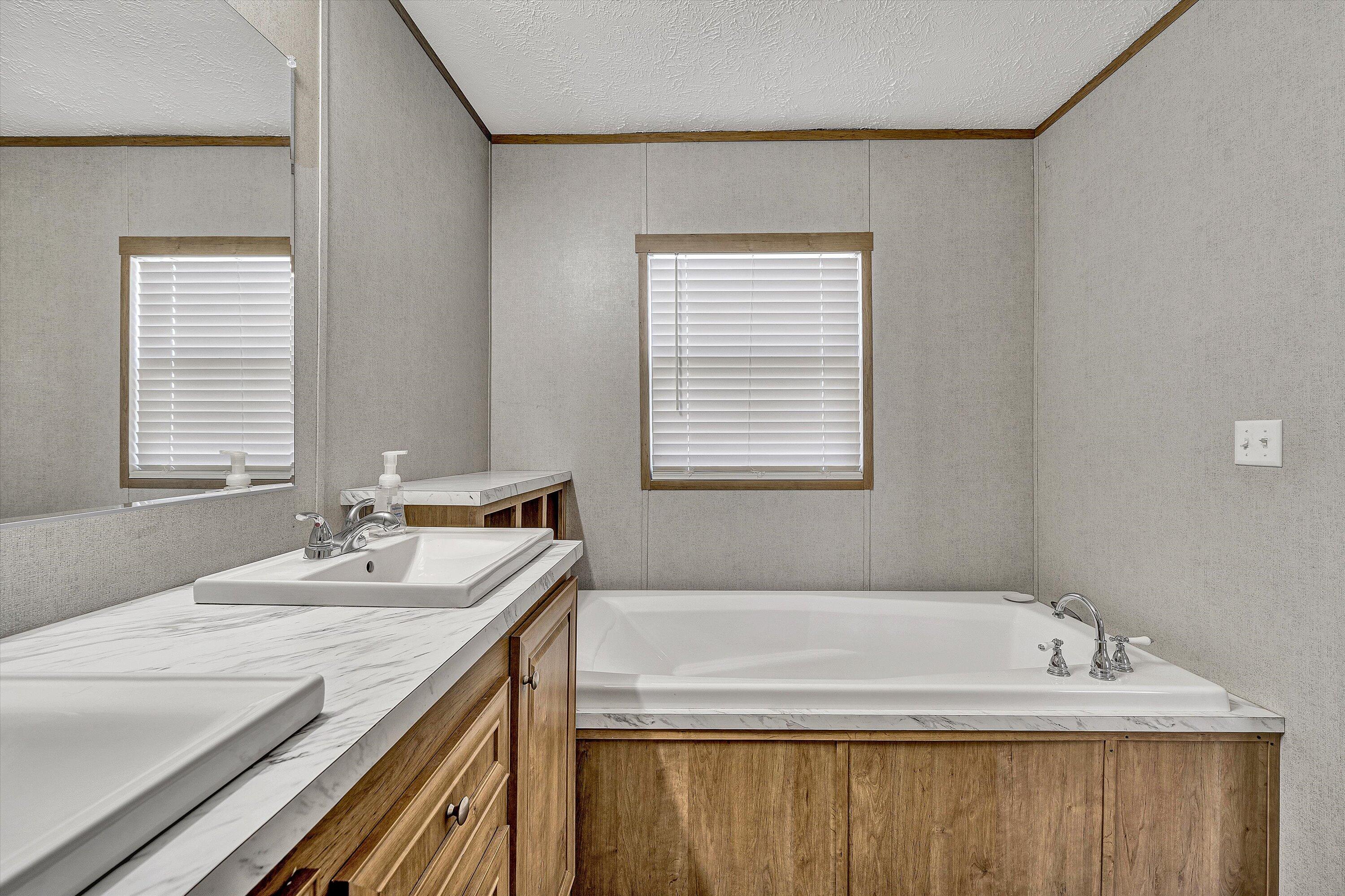 1405 Doe Run Road Rocky Mount, VA 24151 - Photo 18 of 27 a bathroom with a granite countertop sink and a bathtub