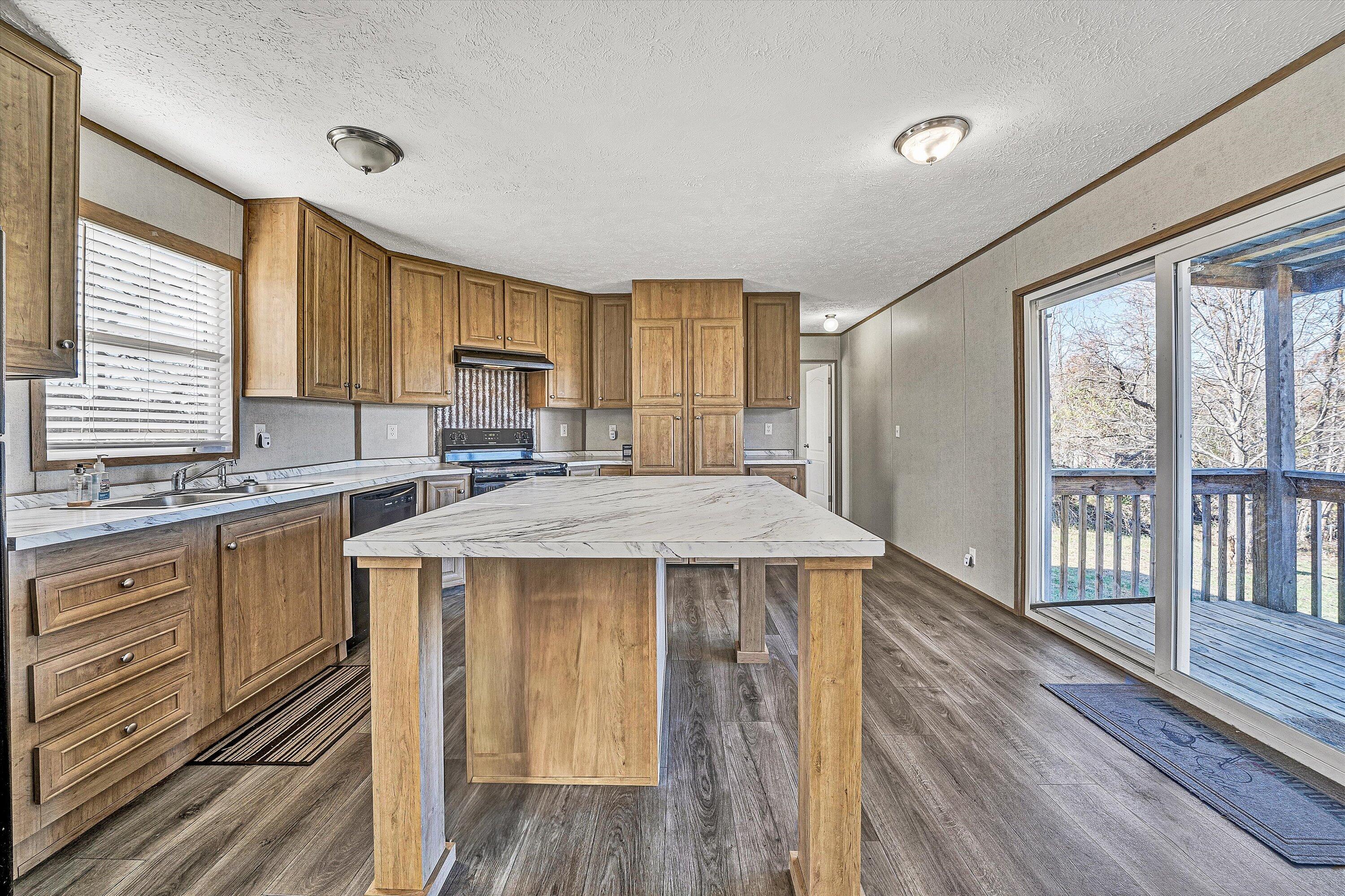 1405 Doe Run Road Rocky Mount, VA 24151 - Photo 7 of 27 a kitchen with a stove a sink and a refrigerator