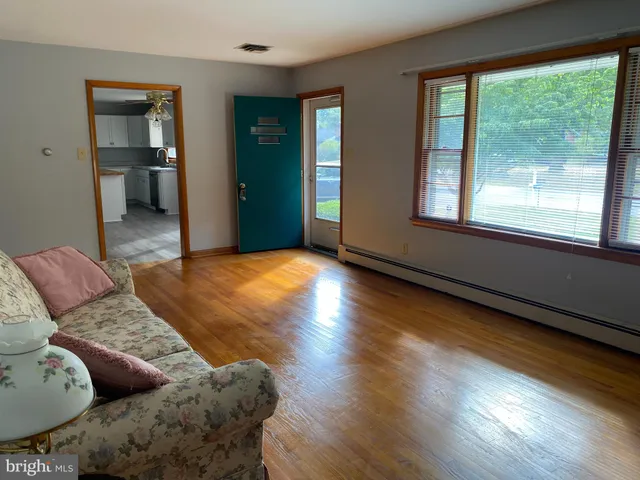 a bed sitting in a spacious bedroom next to a window