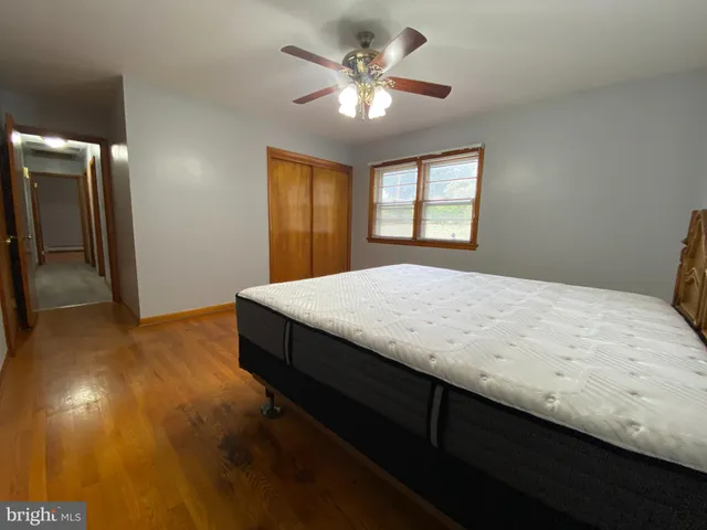 a view of an empty room with window and a ceiling fan