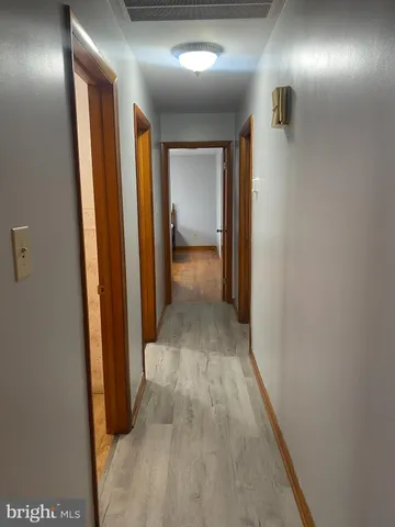 a view of a hallway with wooden shelves