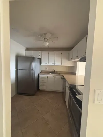a kitchen with a refrigerator sink and cabinets