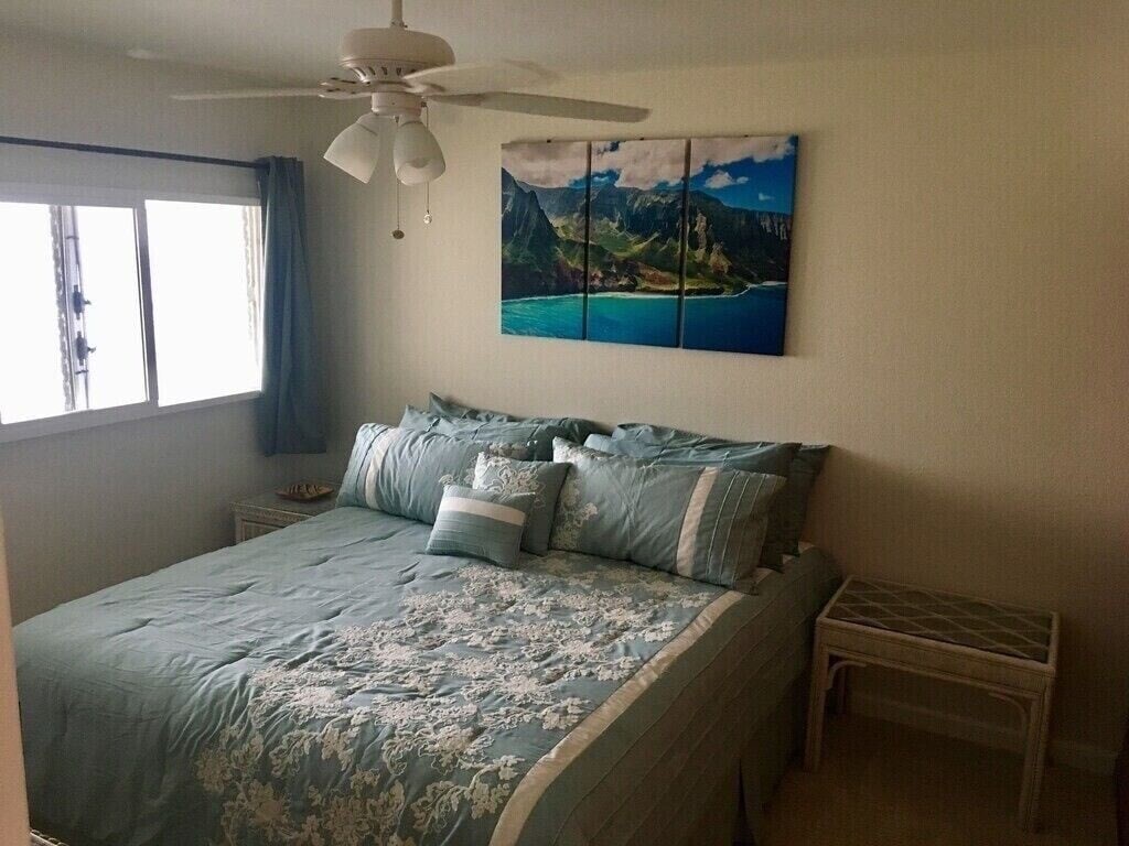 320 Papaloa Road, Unit 302 Kapaa, HI 96746 - Photo 9 of 16 a bed sitting in a bedroom next to a window