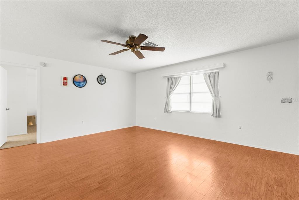 22249 Powell Road Brooksville, FL 34601 - Photo 20 of 43 a view of empty room with wooden floor and fan