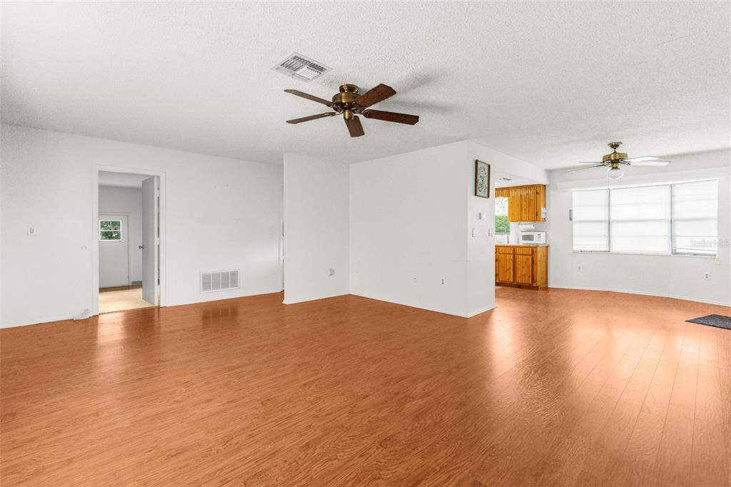 22249 Powell Road Brooksville, FL 34601 - Photo 22 of 43 an empty room with wooden floor and windows