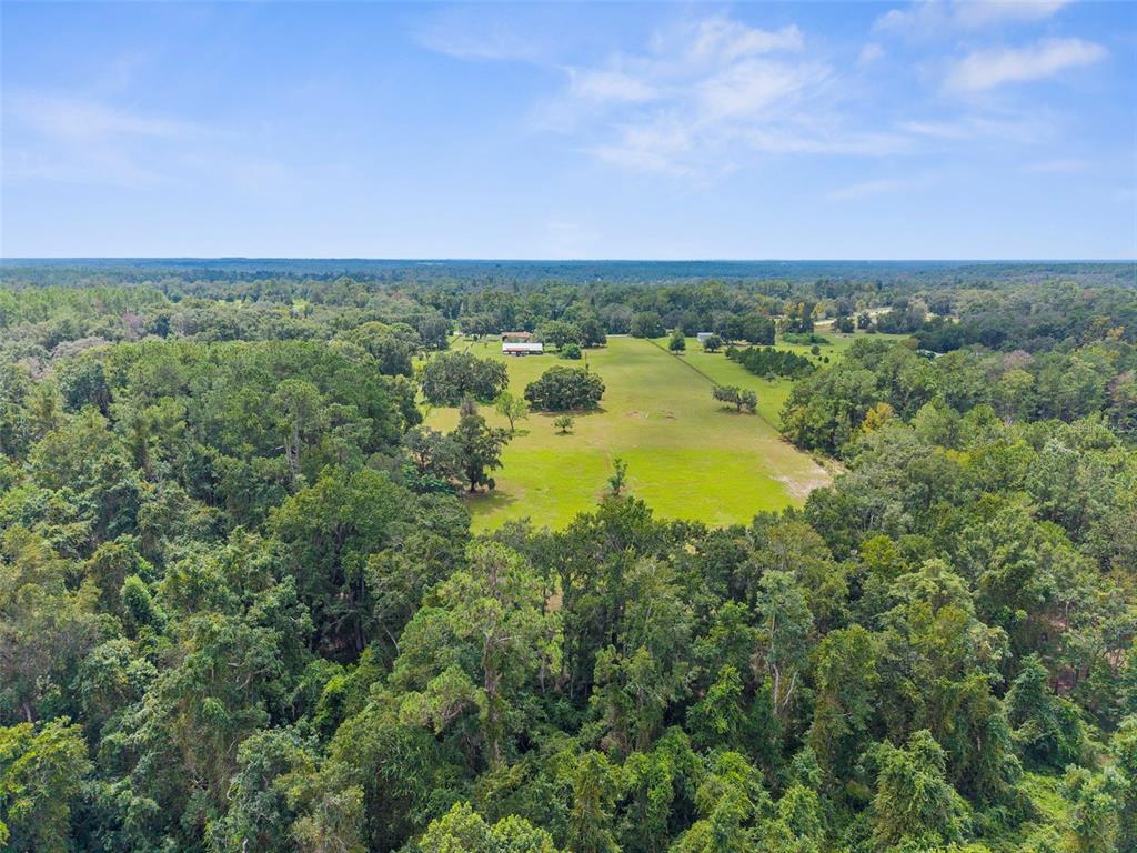 22249 Powell Road Brooksville, FL 34601 - Photo 10 of 43 an aerial view of a houses with a lake and mountain view in back