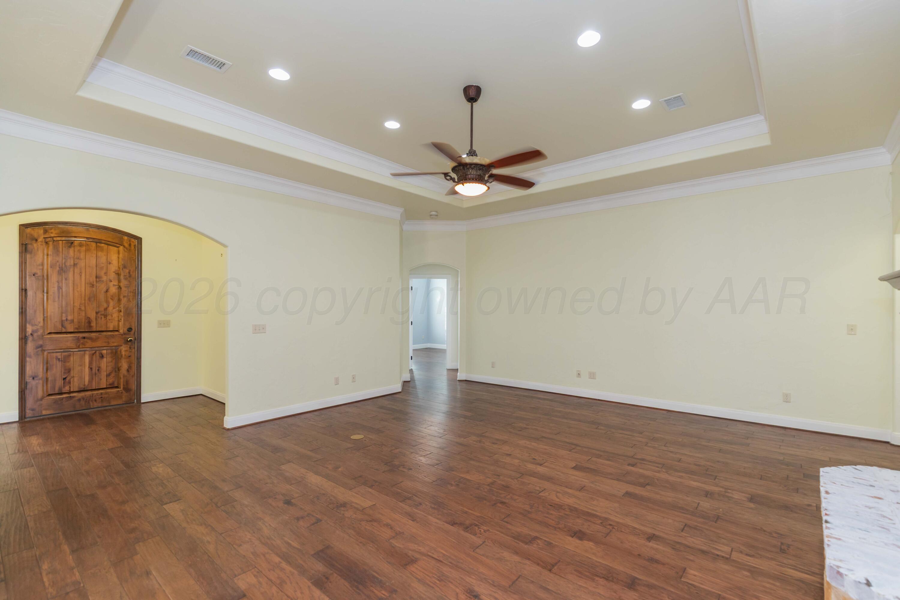 7718 Pinnacle Drive Amarillo, TX 79119 - Photo 11 of 66 an empty room with wooden floor and a ceiling fan