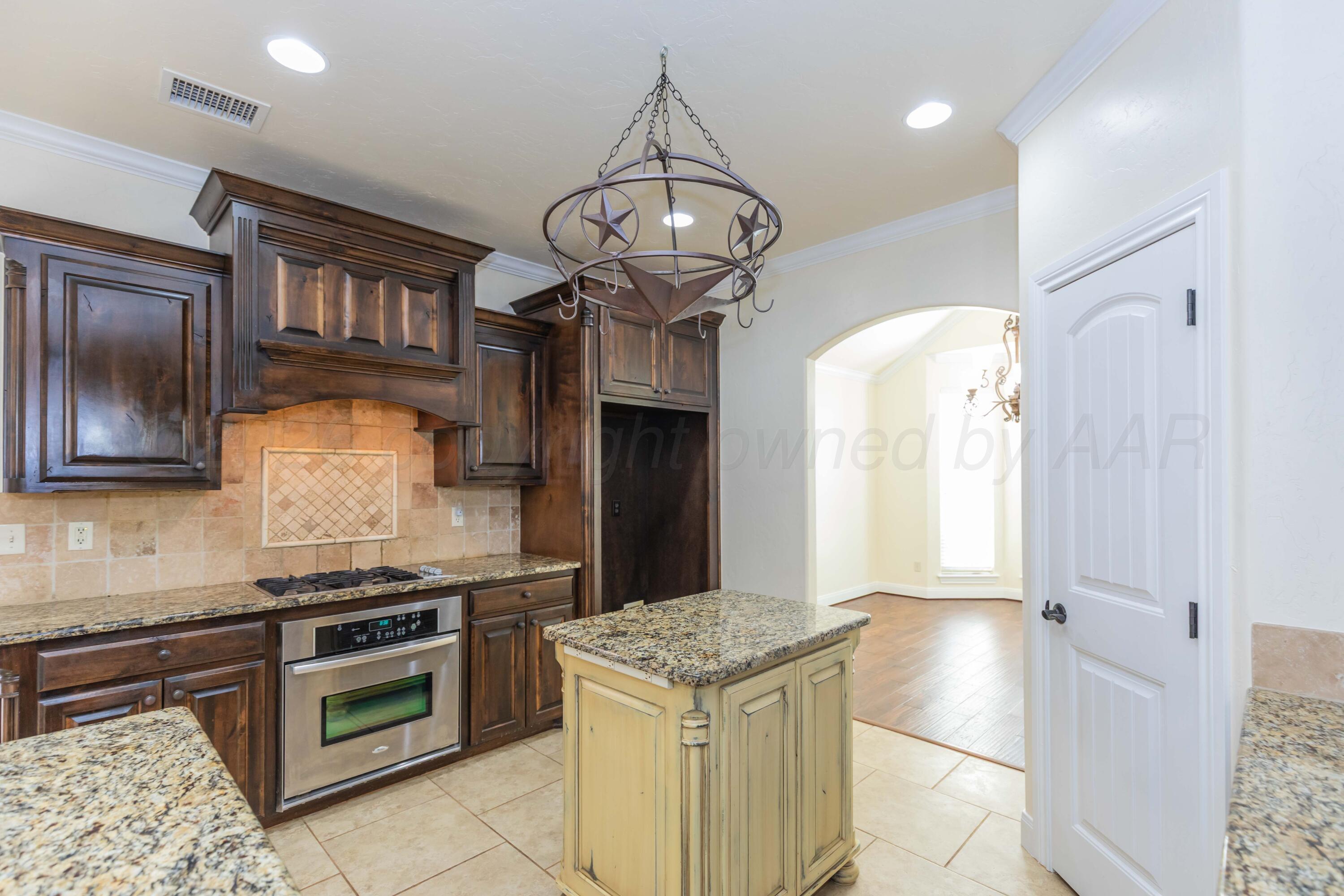 7718 Pinnacle Drive Amarillo, TX 79119 - Photo 15 of 66 a kitchen with stainless steel appliances granite countertop a stove and a refrigerator