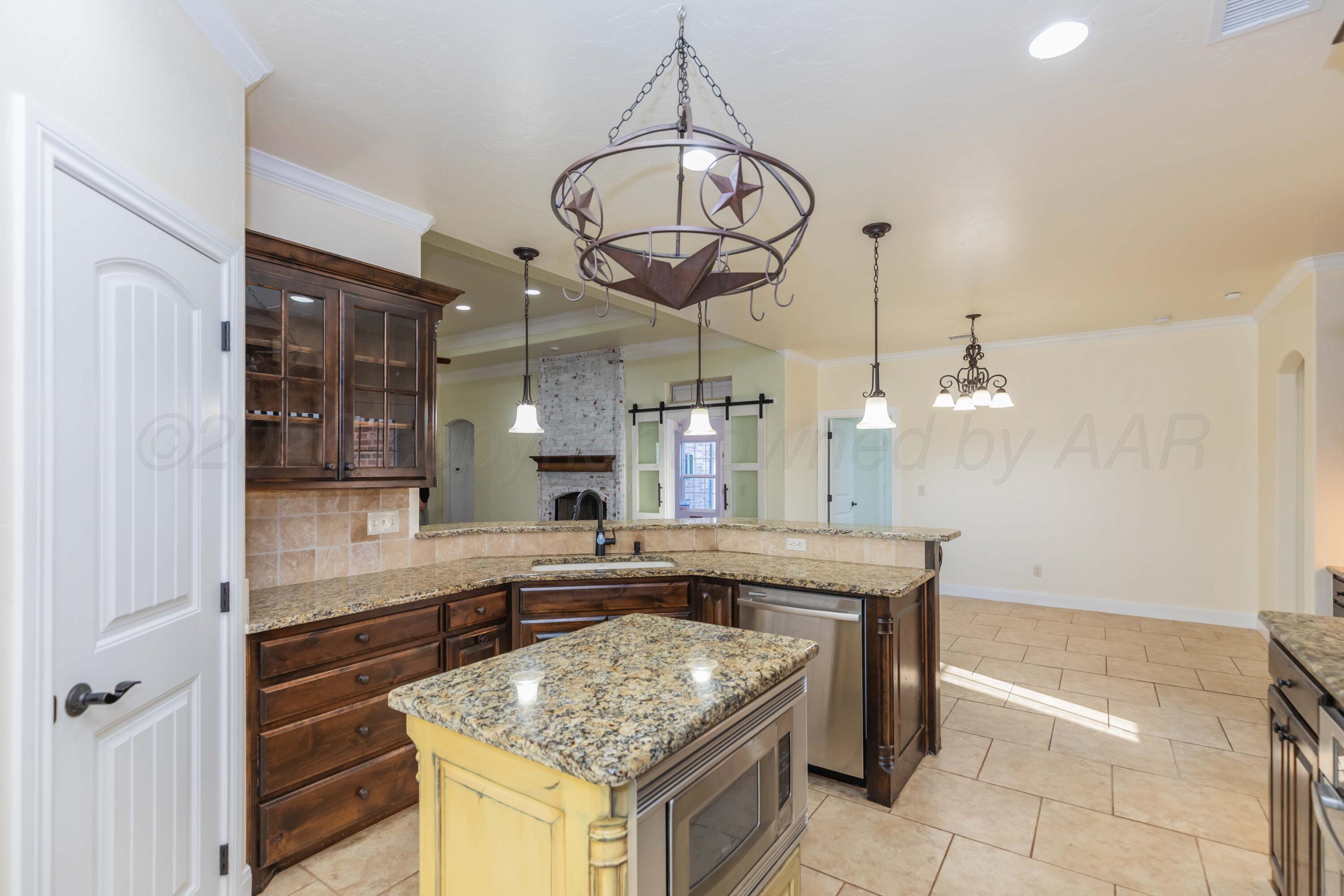 7718 Pinnacle Drive Amarillo, TX 79119 - Photo 17 of 66 a kitchen with stainless steel appliances granite countertop a stove and a refrigerator