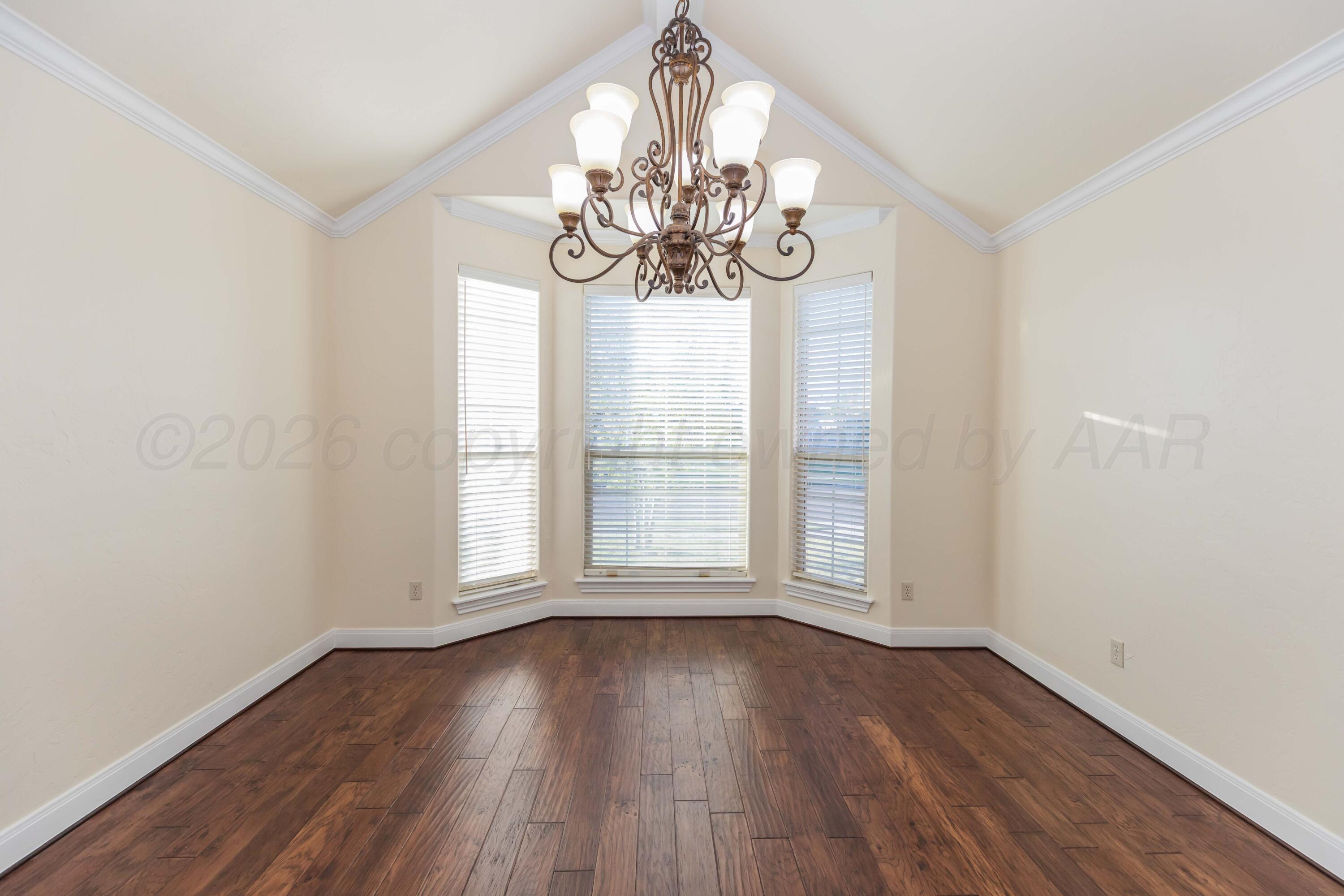 7718 Pinnacle Drive Amarillo, TX 79119 - Photo 22 of 66 a view of an empty room with wooden floor and a window