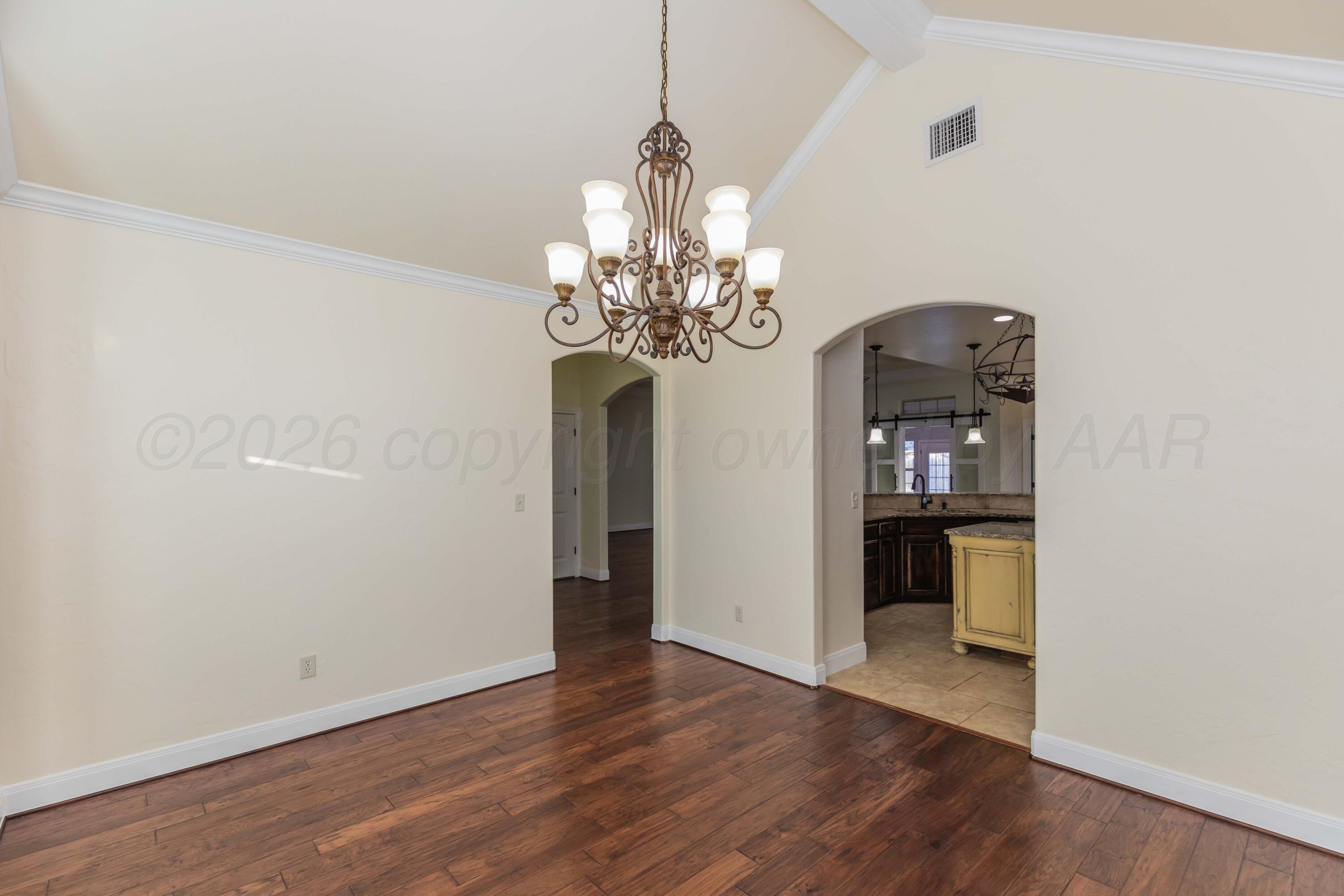 7718 Pinnacle Drive Amarillo, TX 79119 - Photo 24 of 66 a view of a room with wooden floor and chandelier