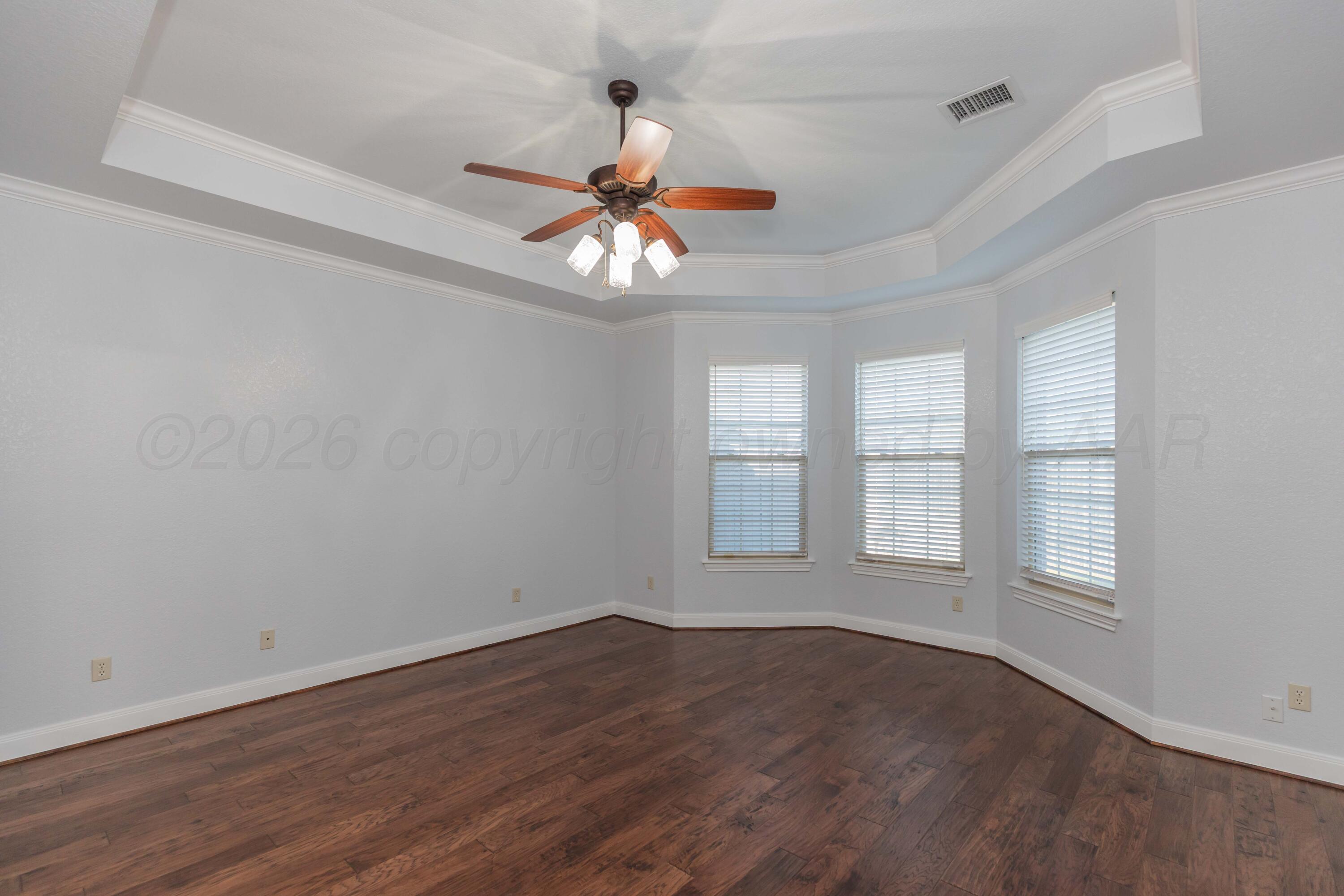 7718 Pinnacle Drive Amarillo, TX 79119 - Photo 26 of 66 an empty room with wooden floor chandelier fan and windows