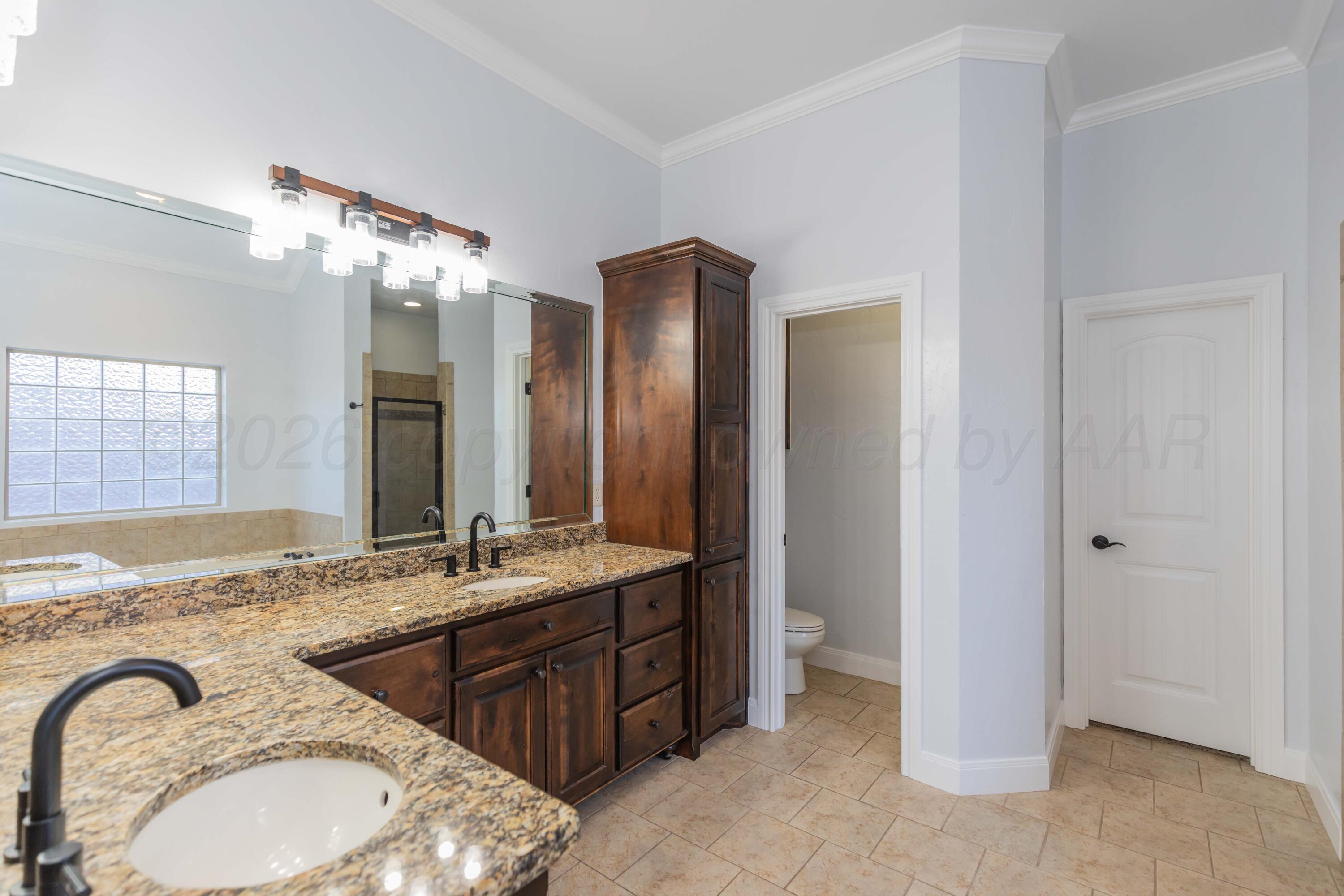 7718 Pinnacle Drive Amarillo, TX 79119 - Photo 30 of 66 a bathroom with a granite countertop sink double vanity and a mirror