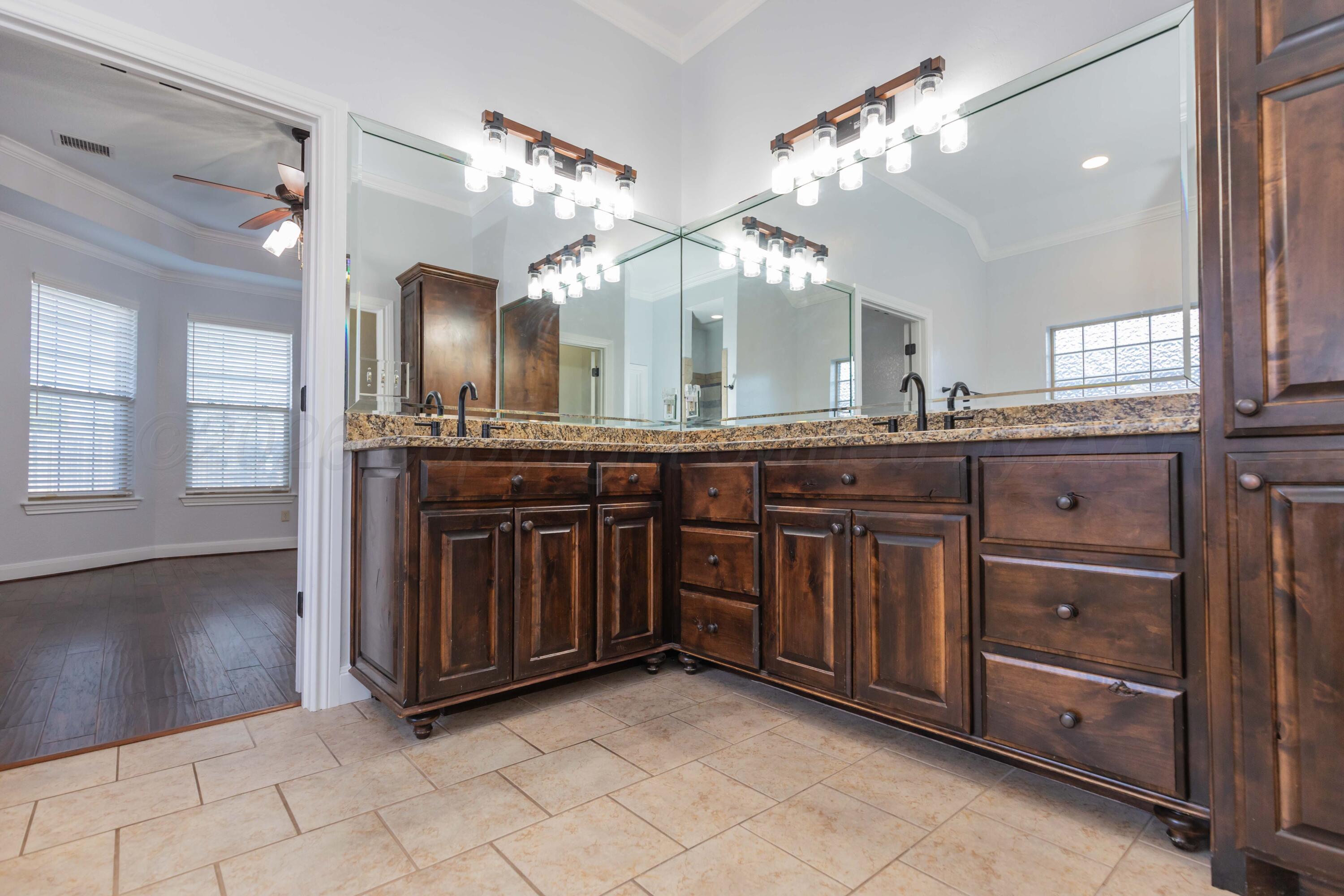 7718 Pinnacle Drive Amarillo, TX 79119 - Photo 31 of 66 a spacious bathroom with a granite countertop double vanity sink and a mirror