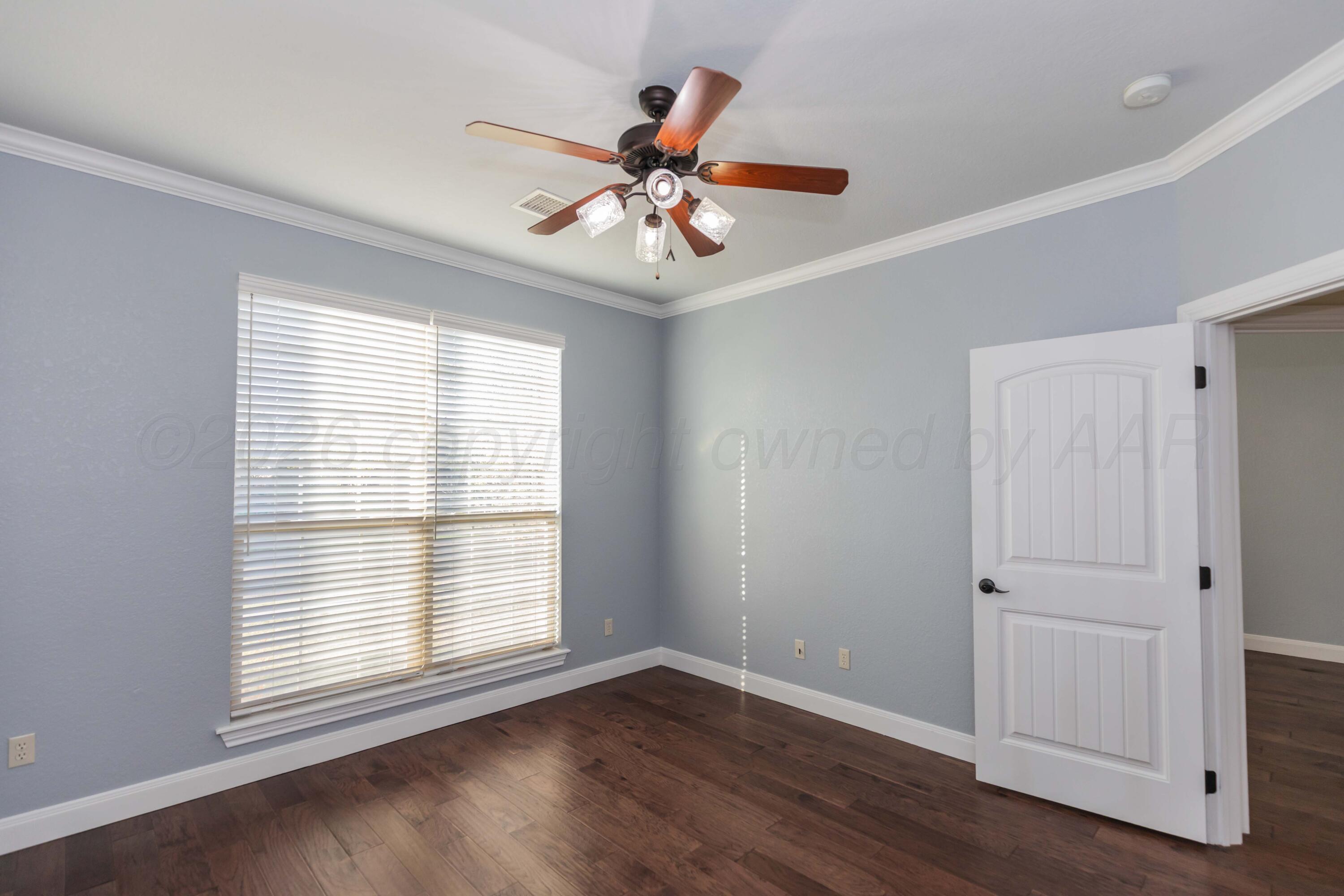 7718 Pinnacle Drive Amarillo, TX 79119 - Photo 38 of 66 a view of an empty room with wooden floor and a window