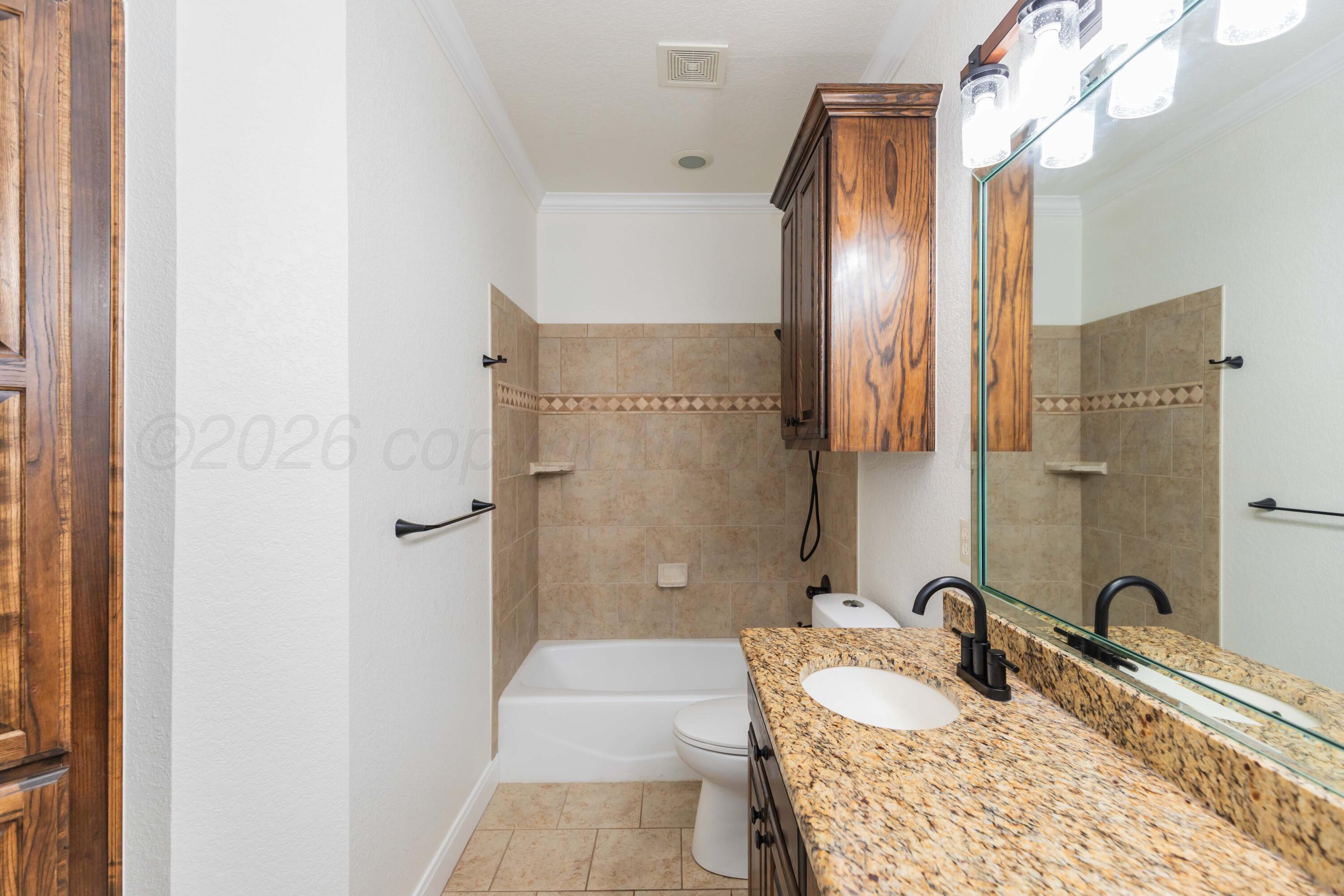 7718 Pinnacle Drive Amarillo, TX 79119 - Photo 42 of 66 a bathroom with a tub sink and mirror